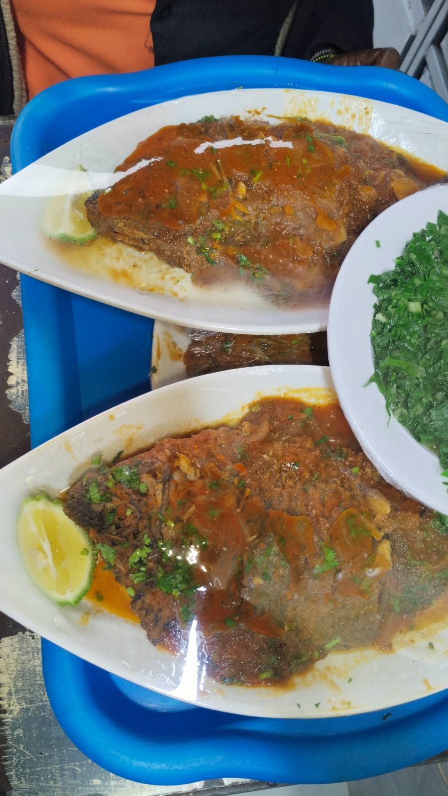Whole fried fish with sauce and greens